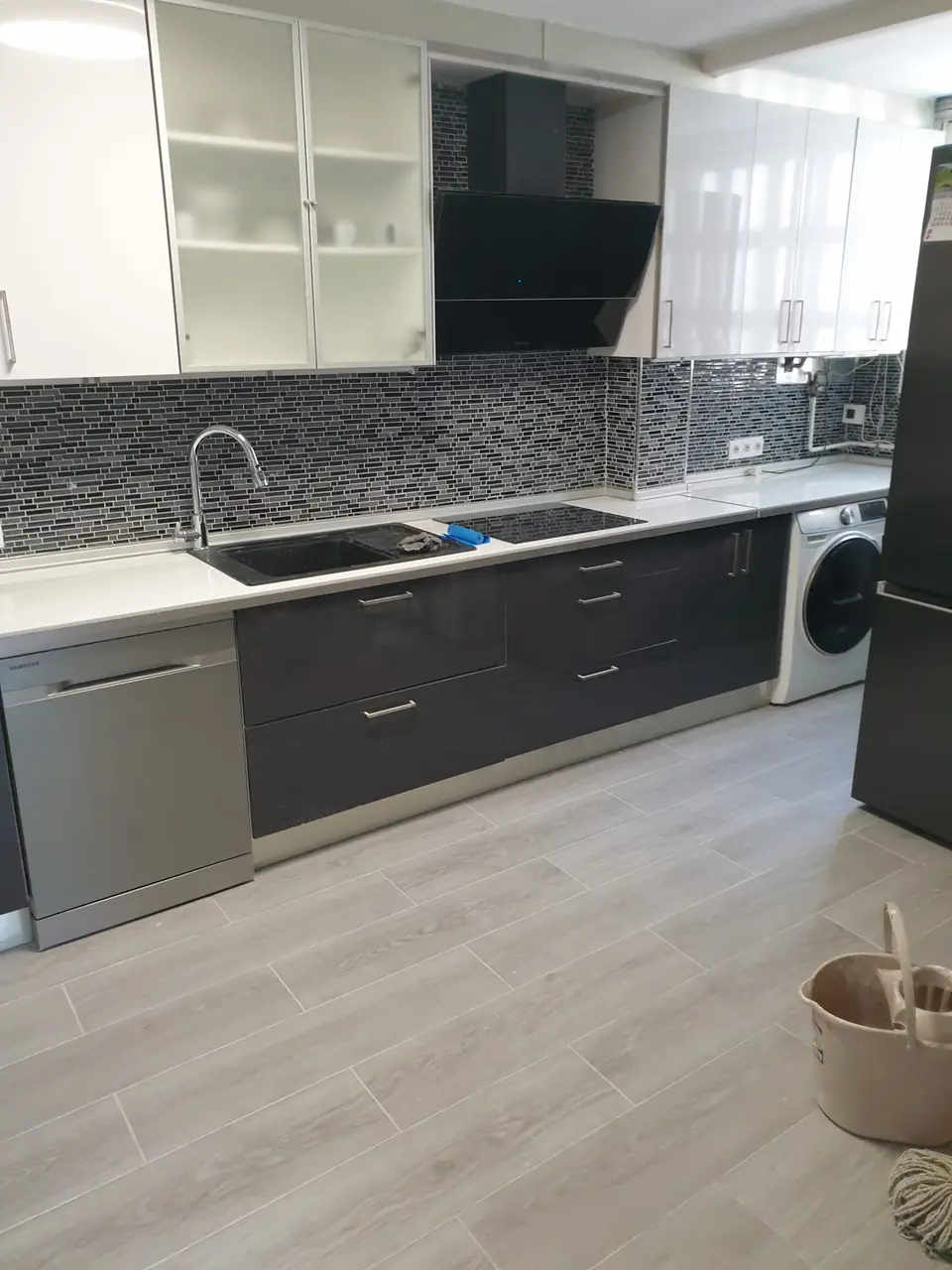 Cocina reformada con muebles gris antracita y blanco brillo, encimera de cuarzo, frente de mosaico y suelo porcelánico
