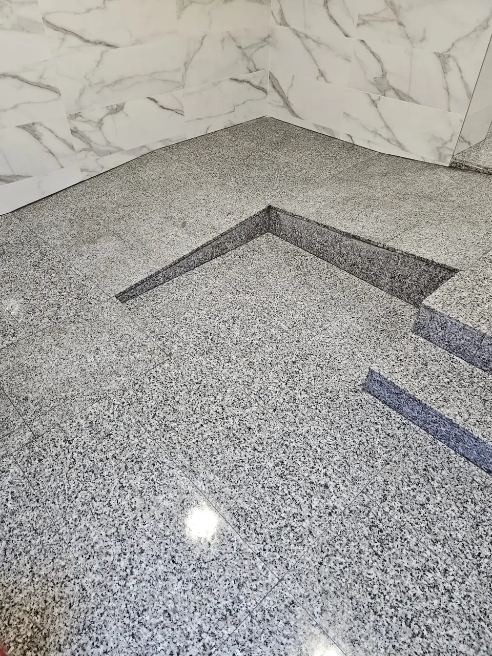 Suelo y peldaños de granito gris pulido en el portal de una comunidad